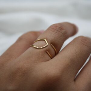 hand wearing a gold wire ring with a point